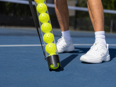Close view of the pickup gate collecting a pickleball from the court